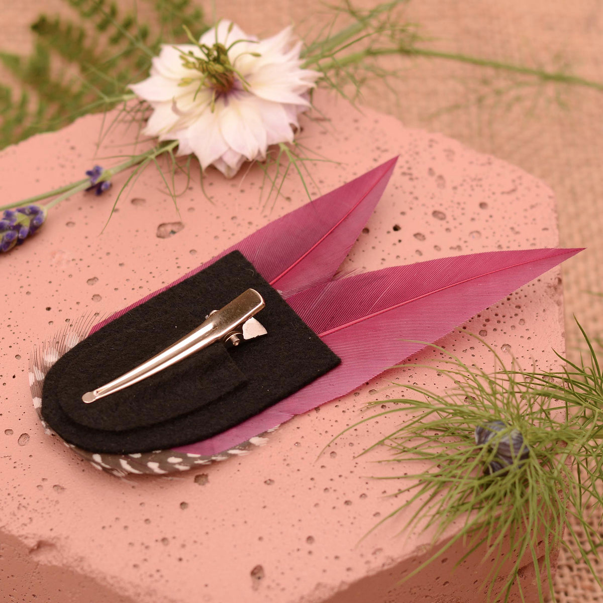 Purple feather hair clip on a black felt base with silver alligator style hair clip.
