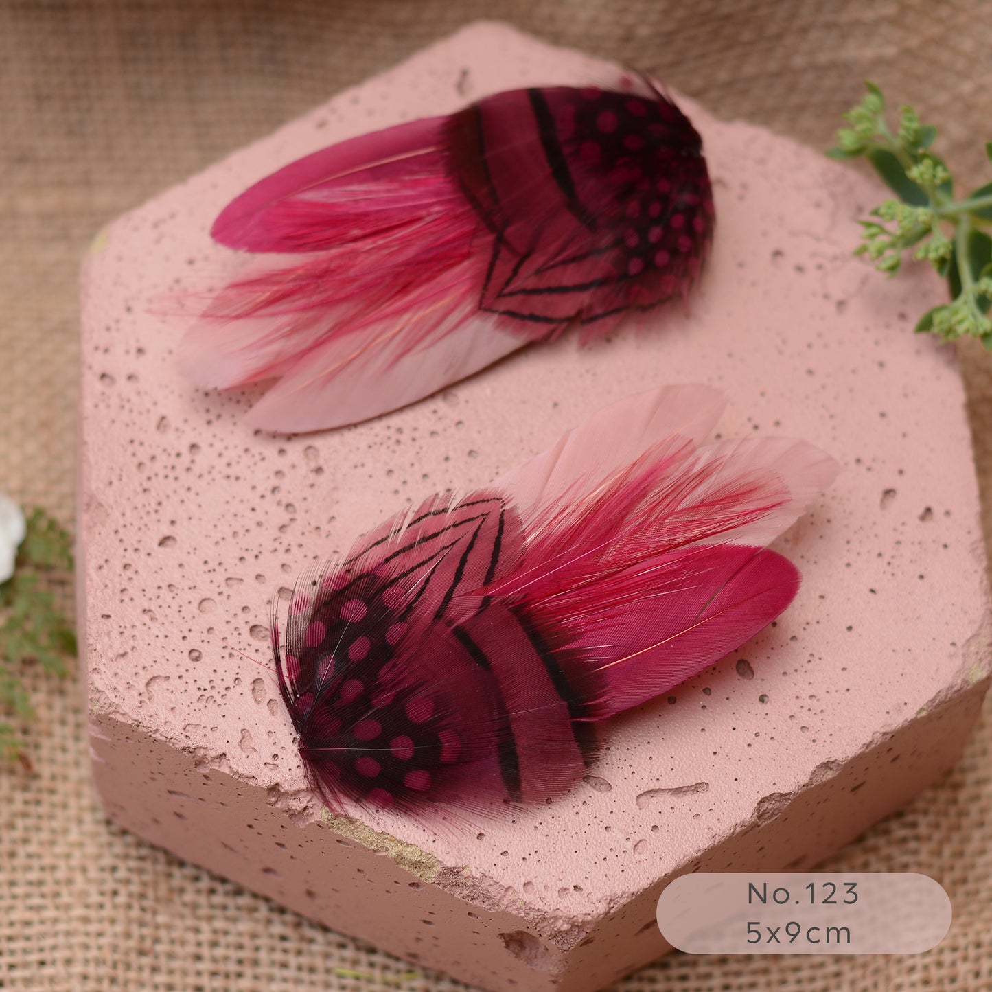 pink and burgundy decorative feather hiar clips on a pink stone