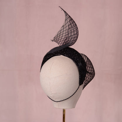 Back veiw of a headband fascinator with sweeping diamond net veil. The hat is secured with a hat elastic.