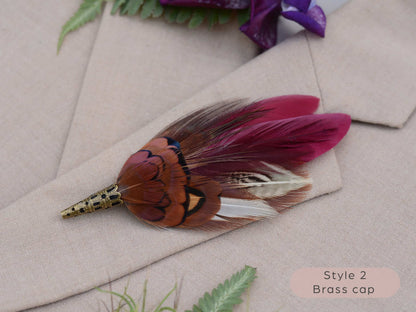Feathered boutonniere with brass cap on a beige fabric background