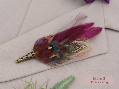 Feathered brooch with brass cap on a light fabric background