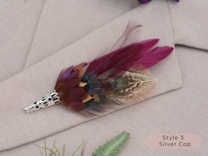 Feathered brooch with silver cap on a light fabric background