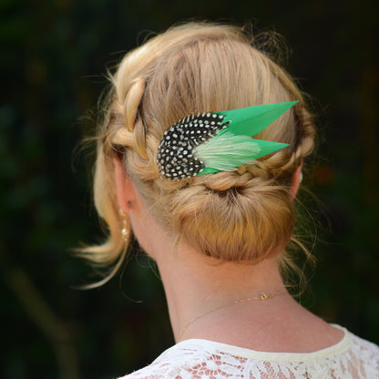 Woman with braided hairstyle with decorative green feather hair clip  with polka-dot spotted feathers