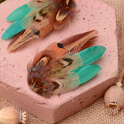 Feather hair accessory in natural pheasant feathers in blonde bronze and copper with green and teal details accented with green feathers.