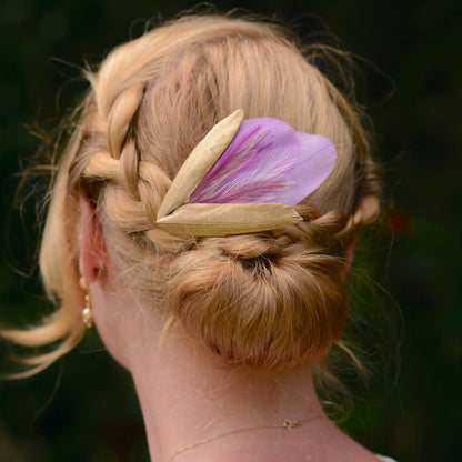 lilac purple and gold decorative feather hair clip fascinator for weddings and special occasions on a blonde model with plaited low bun up-do