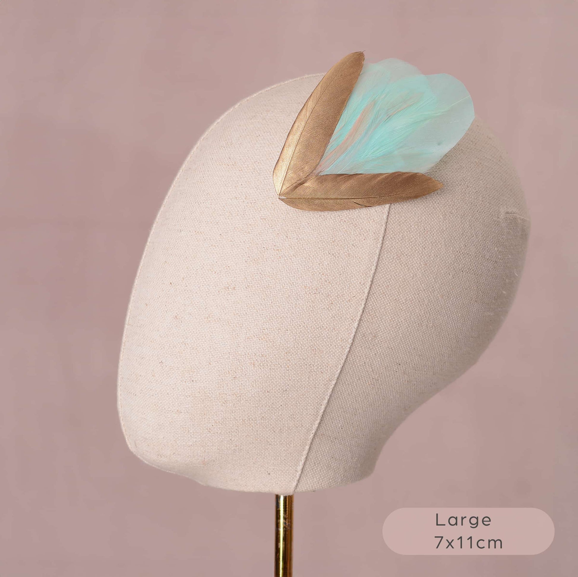 Large mint green and gold feather hair clip on canvas covered mannequin head