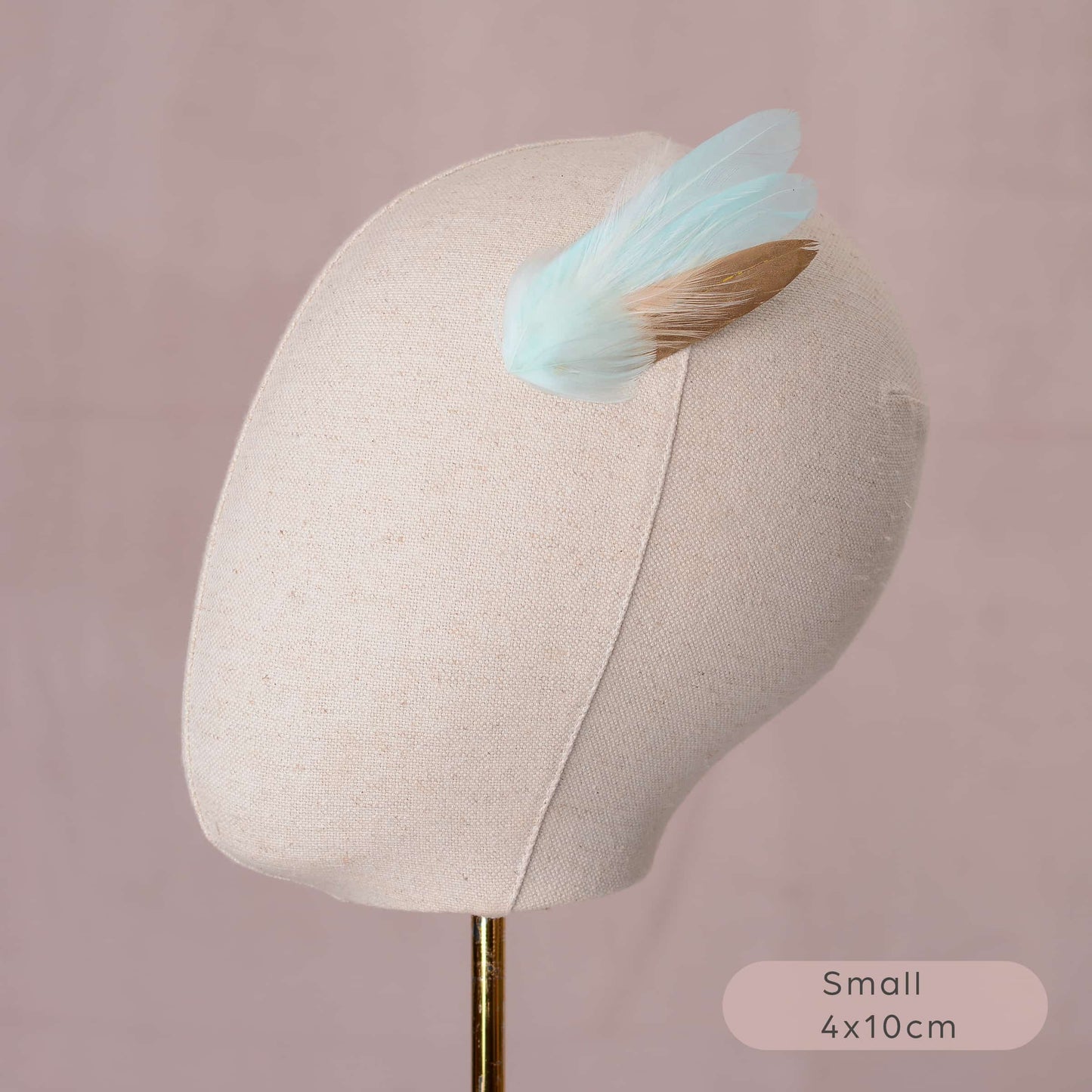 Small mint green and gold feather hair clip on canvas covered mannequin head