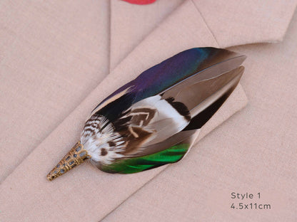 Close up of duck feather brooch pin with iridescent blue and green feathers on a beige jacket.