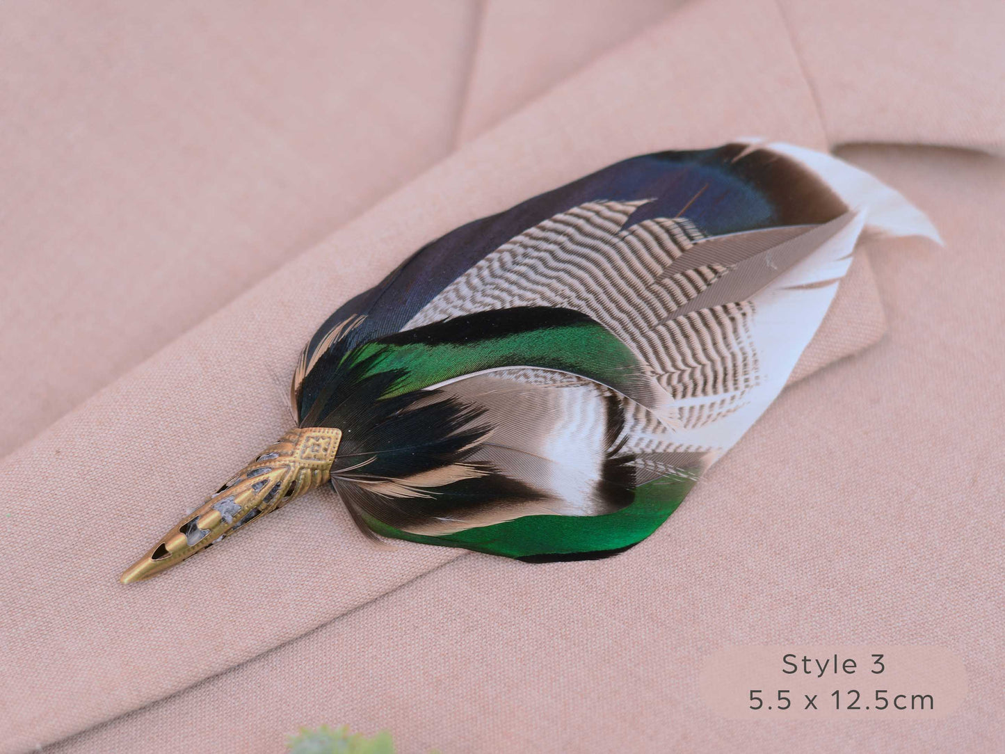 Large duck feather hat pin with iridescent blue and green feathers  with pointed brass cap on a beige jacket 