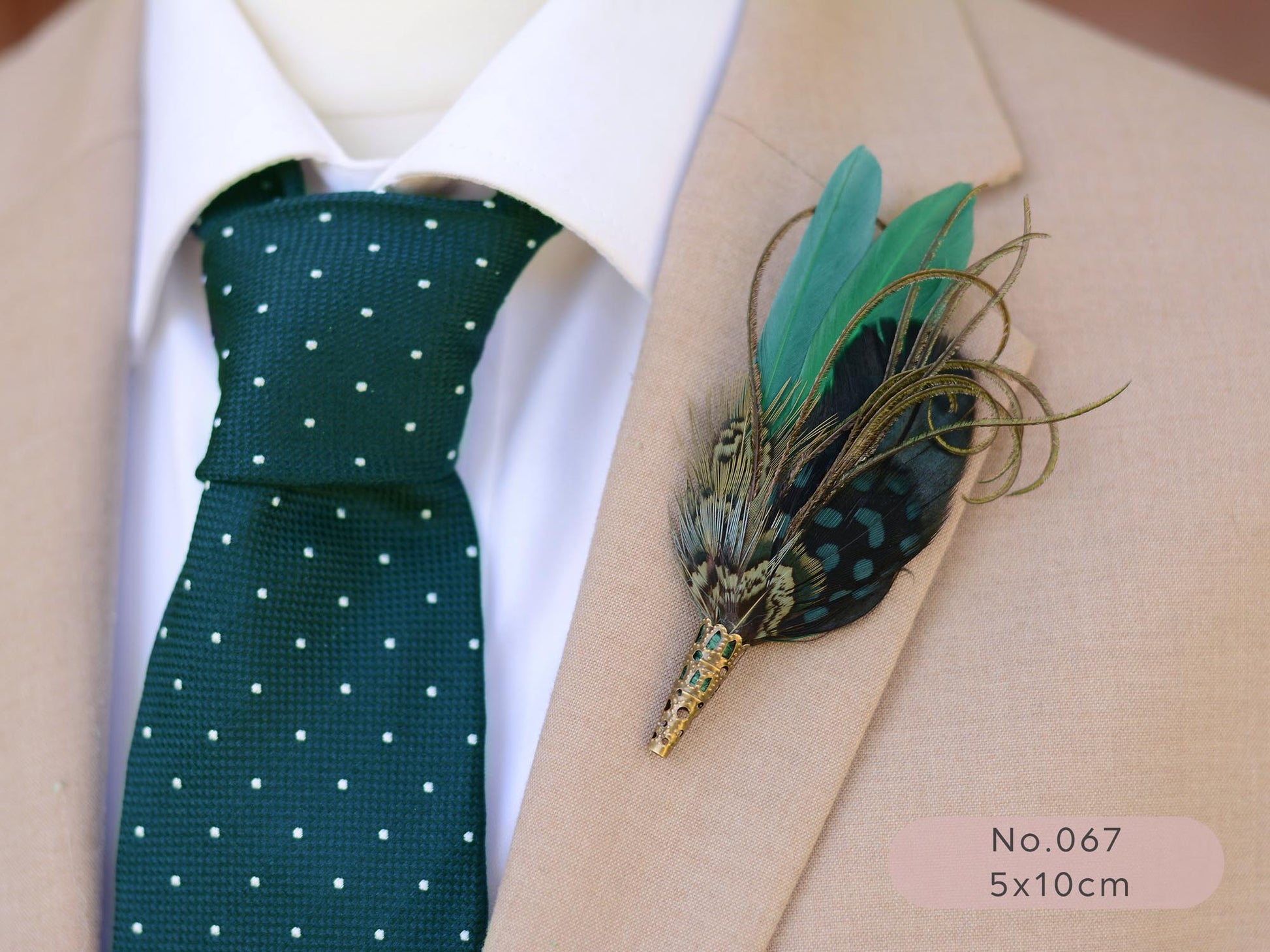 Man wearing a green polka dot tie and beige suit with a green feather boutonniere.
