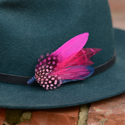 Feather hat pin in hot pink and navy blue on a teal fedora hat