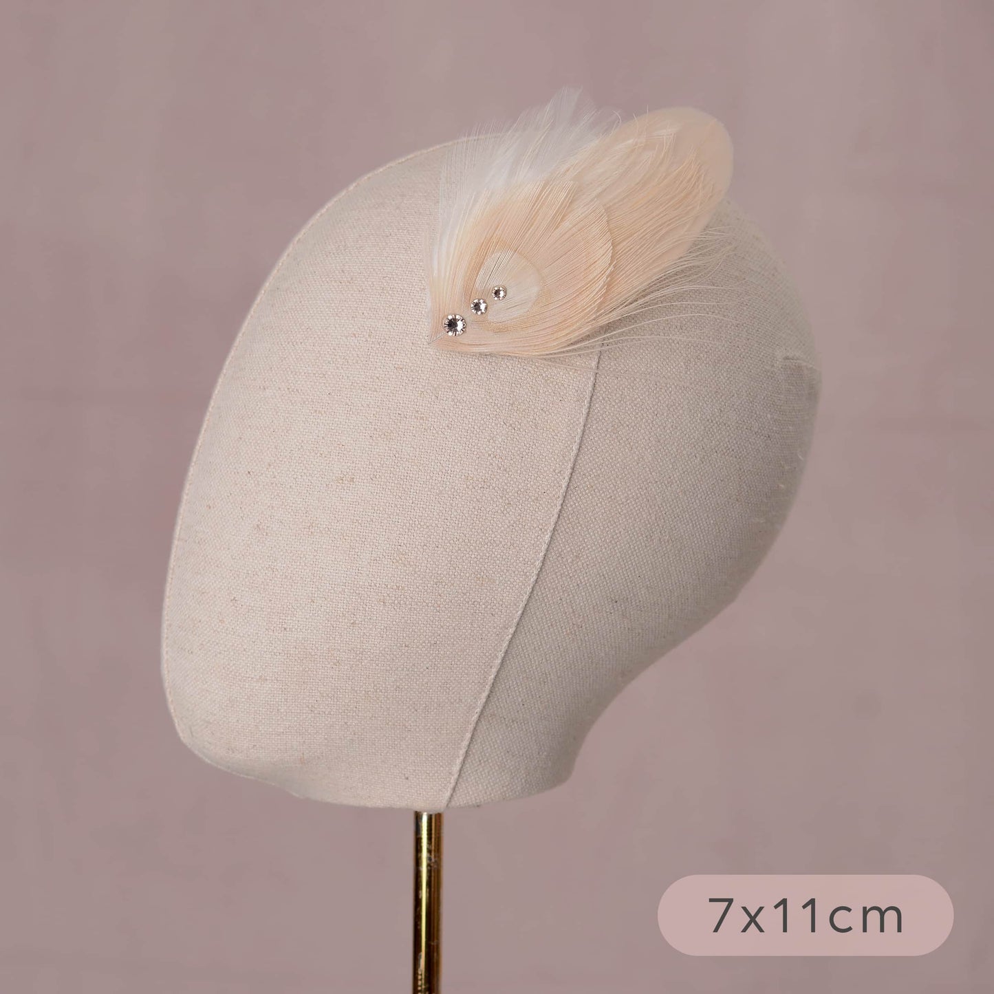 ivory and blush pink peacock Feather hair clip with crystals on a canvas mannequin head with measurements listed 7cm by 11cm