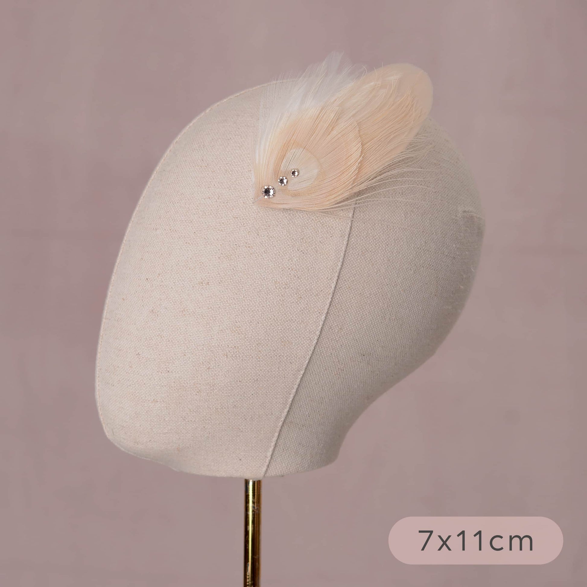 ivory and blush pink peacock Feather hair clip with crystals on a canvas mannequin head with measurements listed 7cm by 11cm