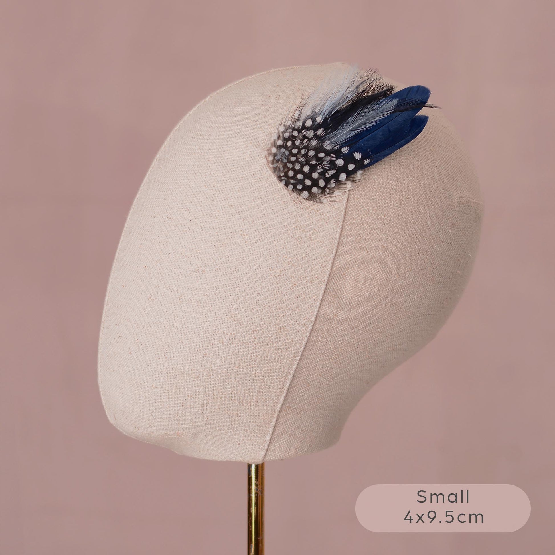 small navy blue feather hair clip on a canvas mannequin head