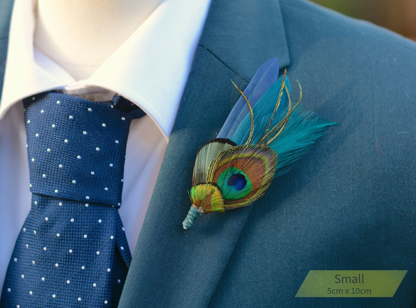Blue suit with peacock feather boutonniere and polka dot tie