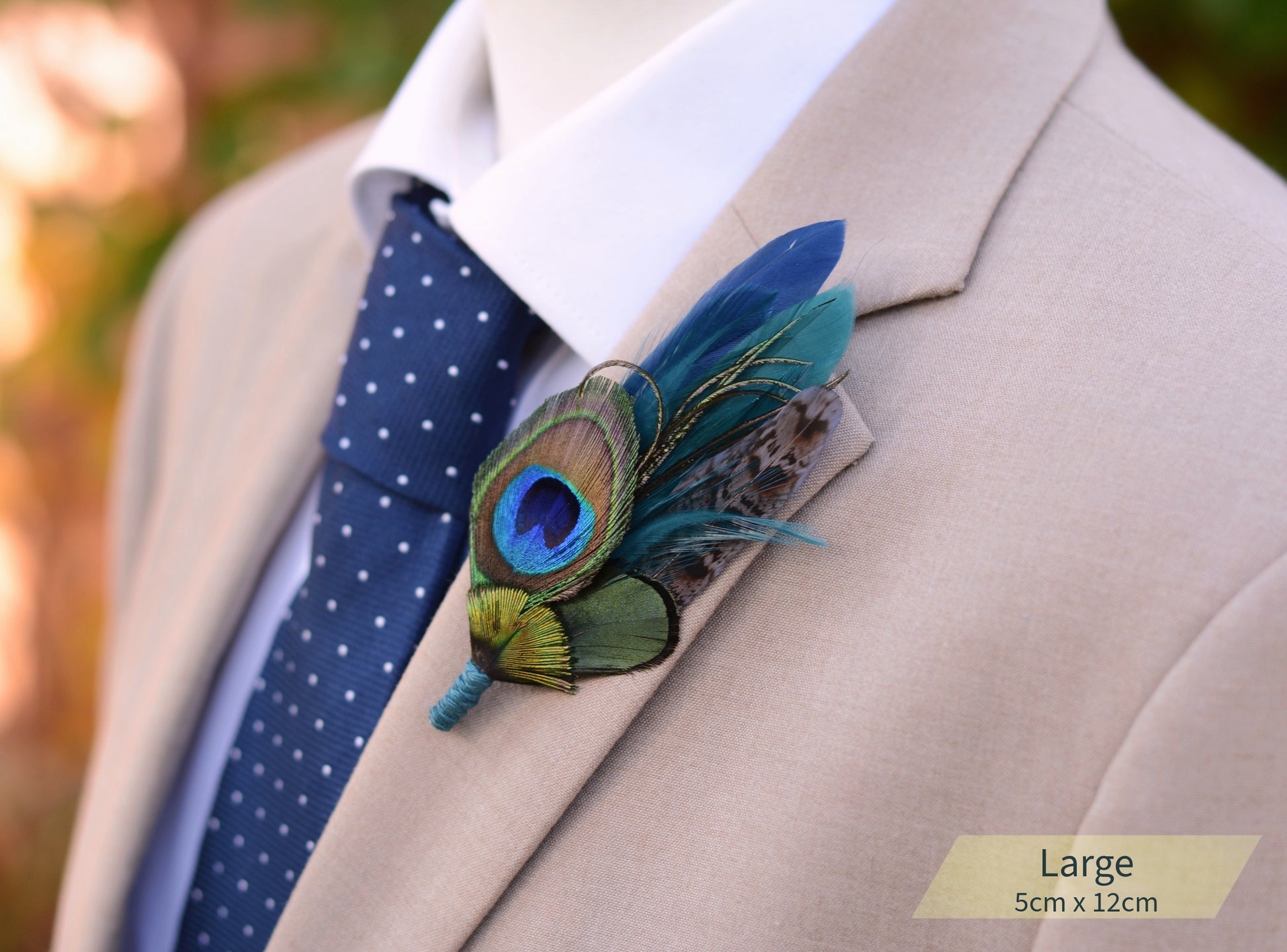 Beige suit with a blue polka dot tie and peacock feather boutonniere.