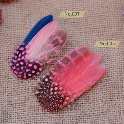 Pink feathered hair clips on a textured beige background