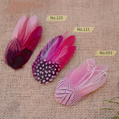 Pink feathered hair clips on a textured beige background
