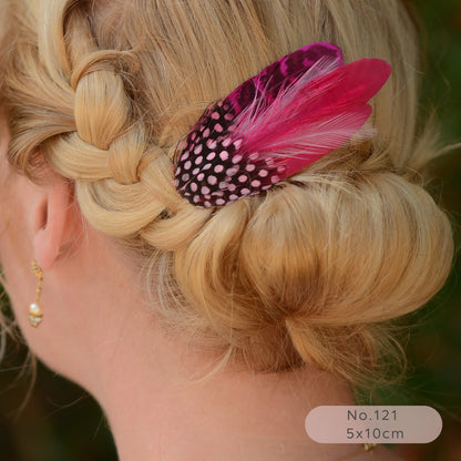 Close-up of a braided hairstyle with a decorative bright pink feather hair clip.