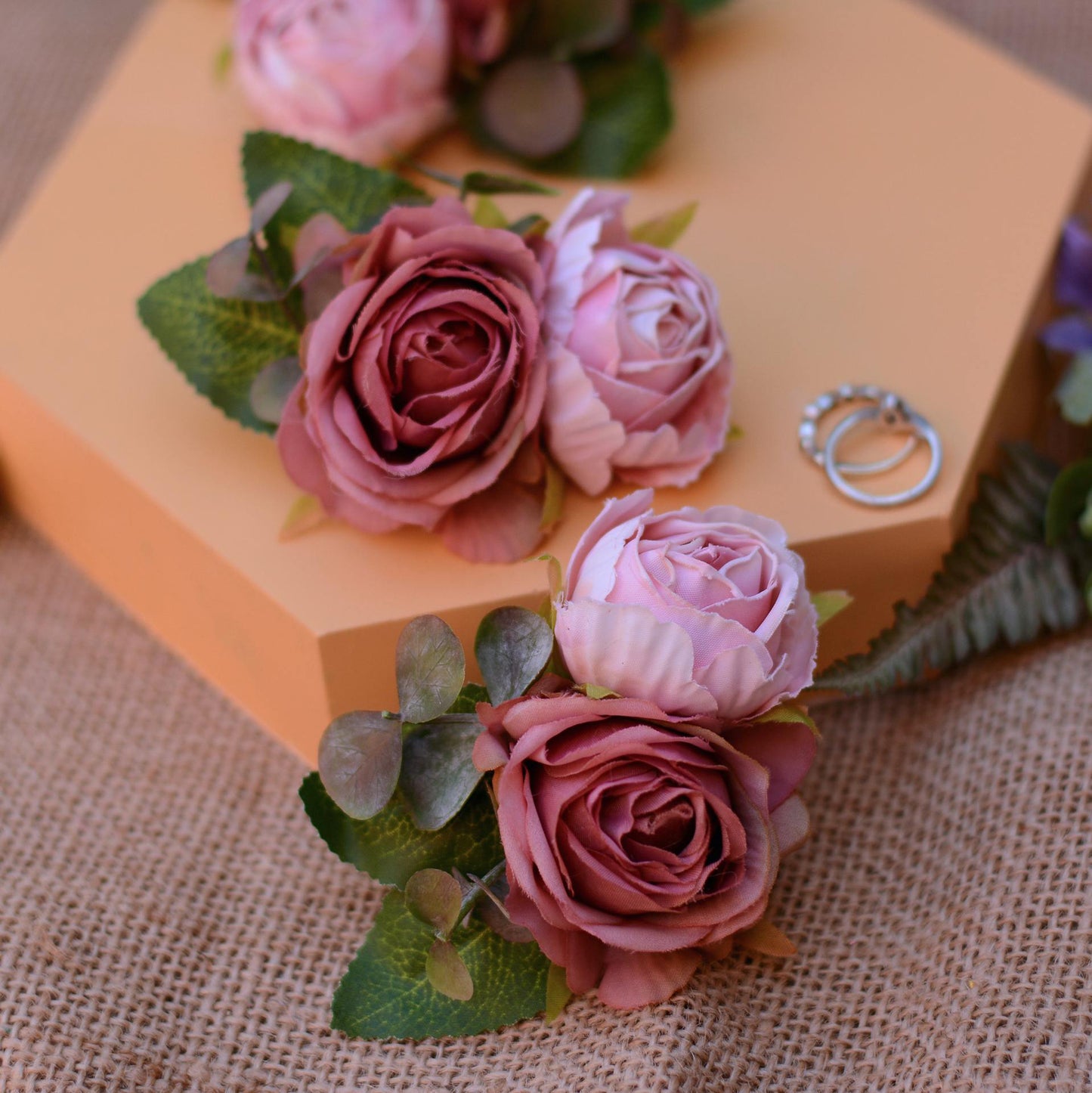 pink rose hair clip accessory on an orange background
