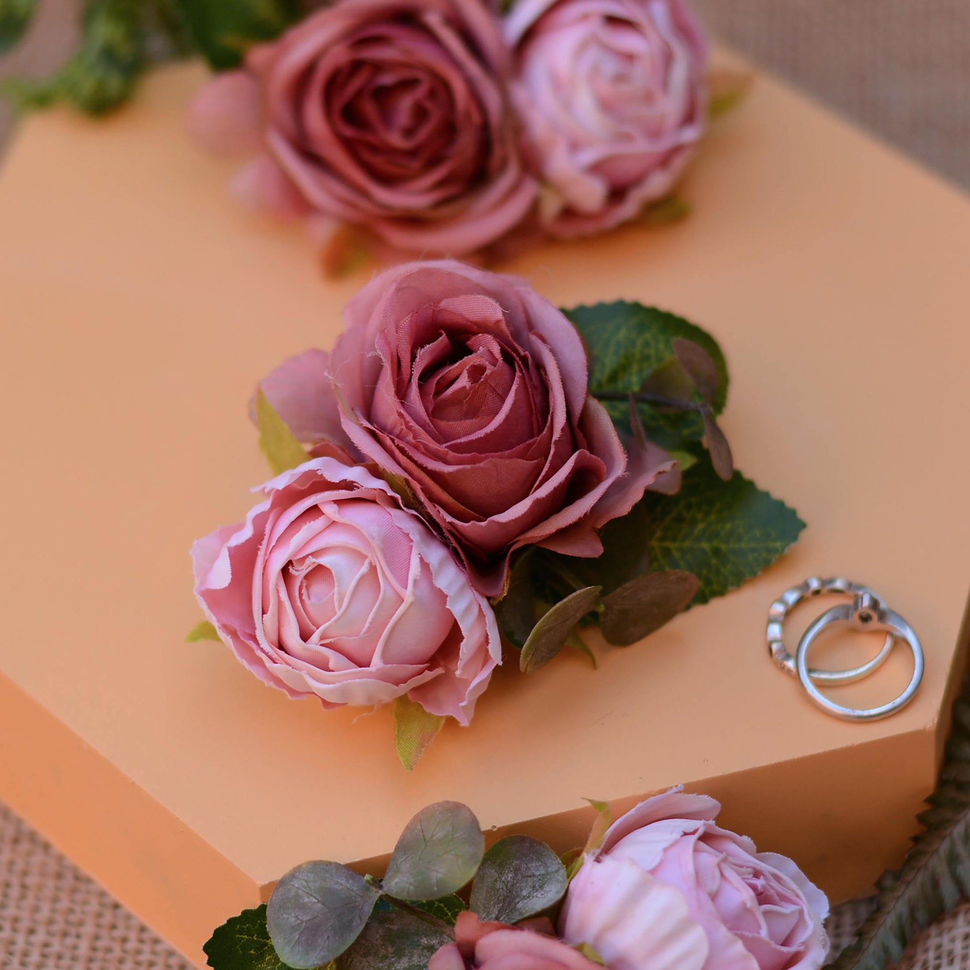 pink rose hair clip accessory on an orange background