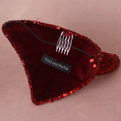 A red sequined and velvet devil headpiece by Flora and the Fox, featuring a silver metal spring clip on the inside.