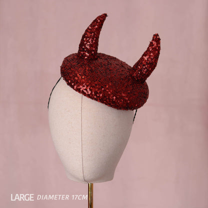 A red sequin devil horn beret hat displayed on a cream fabric mannequin head against a dusty pink background, with text in the lower-left corner reading 'LARGE DIAMETER 17CM'.