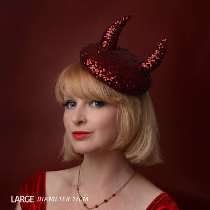 A woman with a short blonde bob wears a red sequin devil horn beret hat against a dark red background. The text 'LARGE DIAMETER 17CM' is visible in the bottom-left corner.