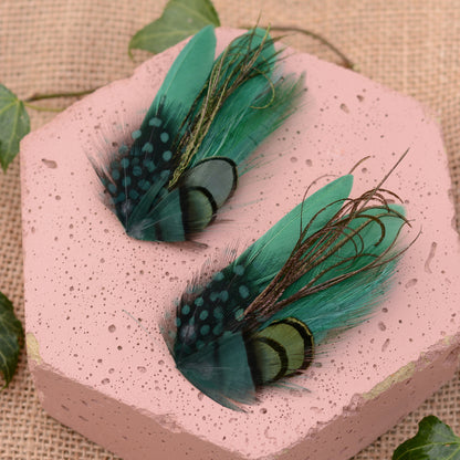 small green feather hair clips on a pink textured stone and beige background