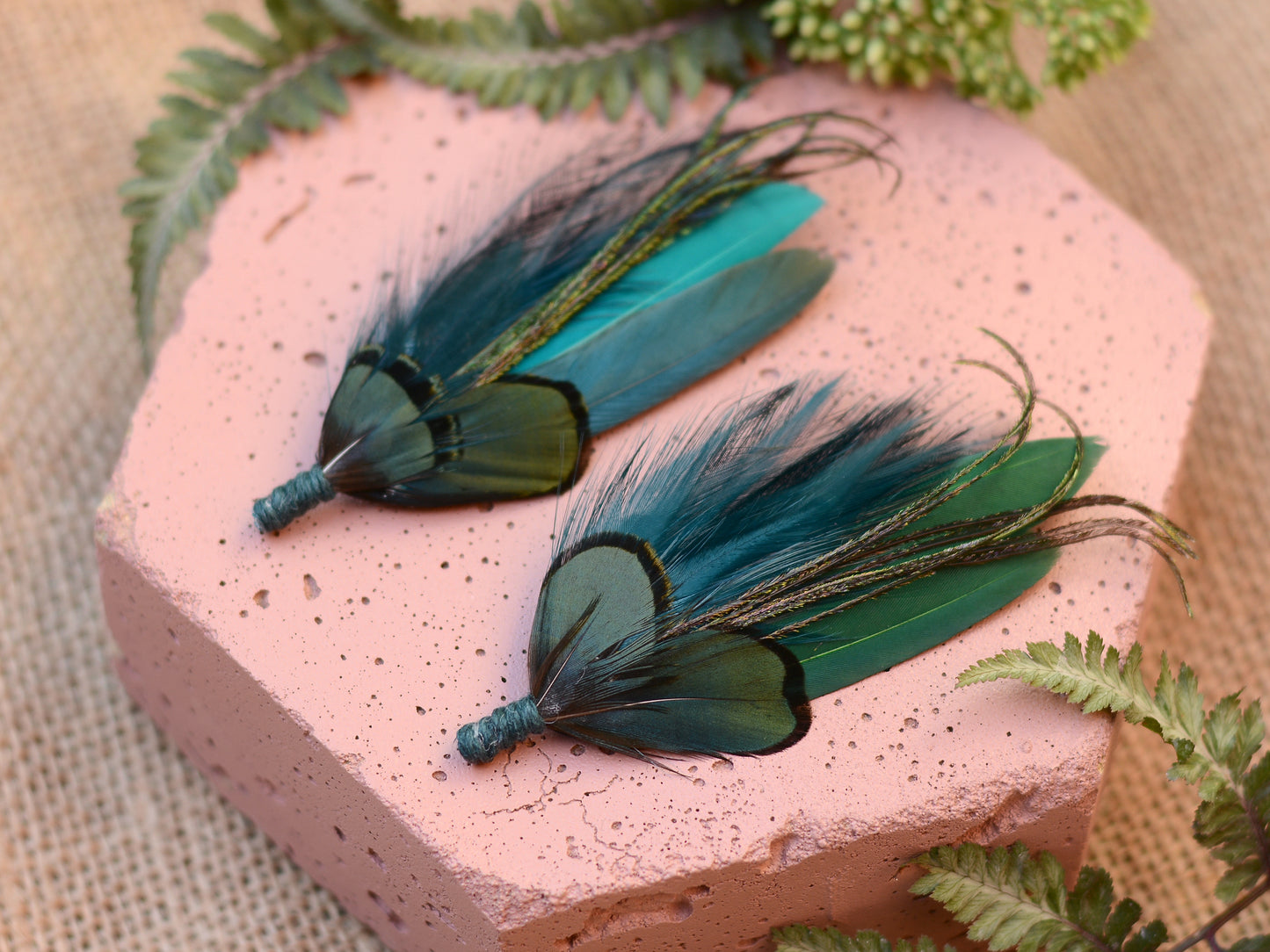 Pair of teal and green feather brooch pins on pink stone