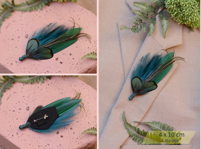 Green feathered brooch on a pink surface with a plant in the background