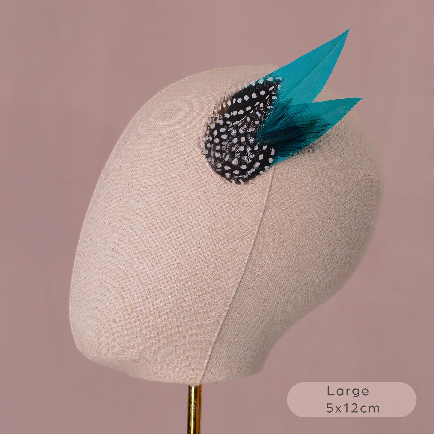 Feathered hair accessory on a mannequin head with a pink background