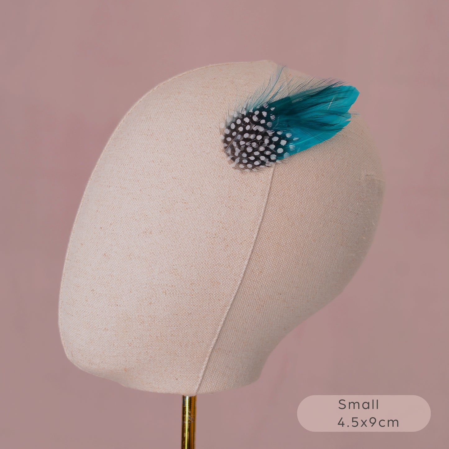 Feathered hair accessory on a mannequin head with a pink background